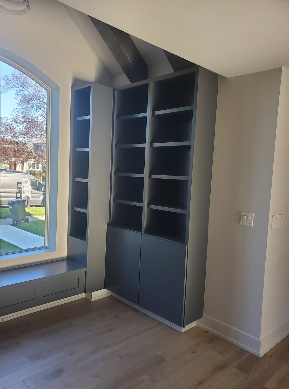 Custom navy built-in shelving and window seat by Too Much Construction